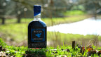 Blue Jay Meadery bottle on grass with blurred background